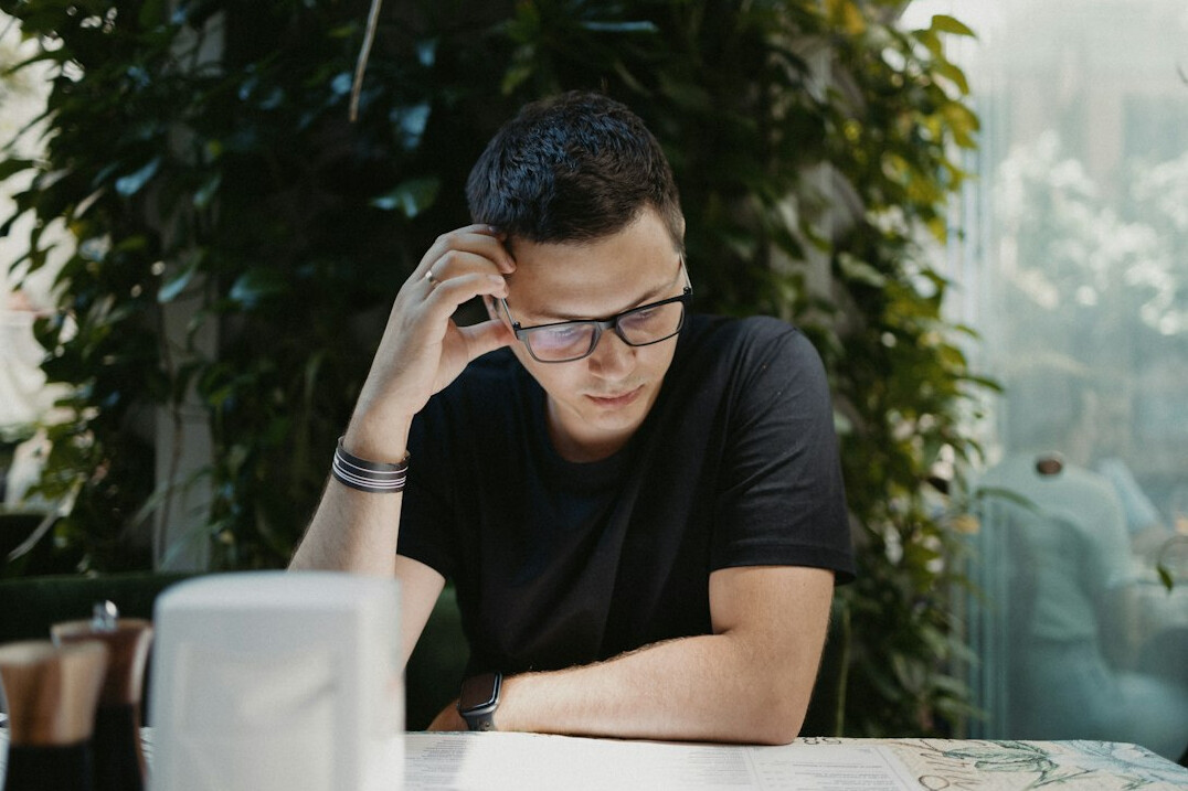 person thinking alone in cafe