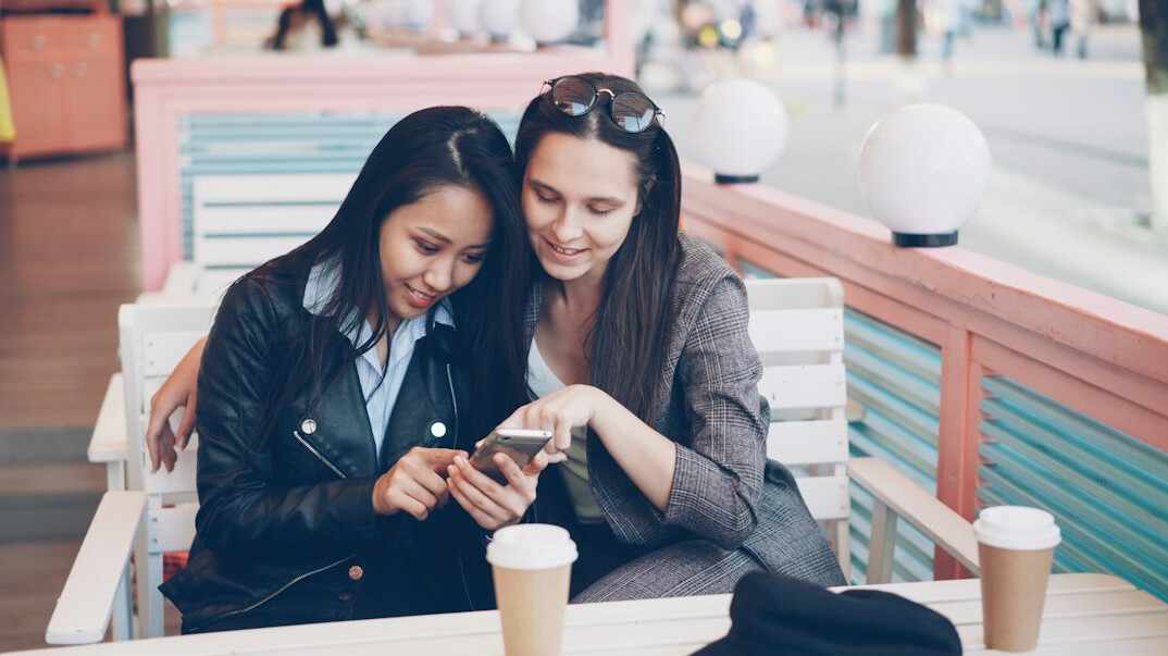 people scrolling on phones in cafe